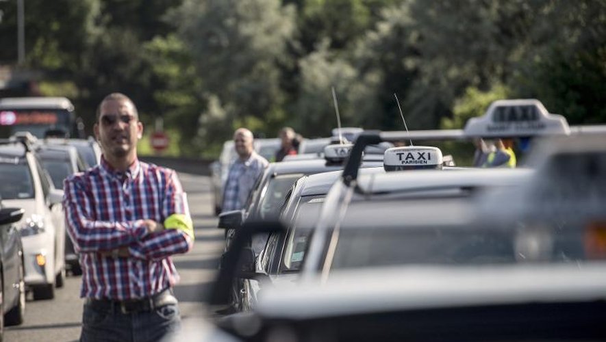 Un chauffeur de taxi en grève au milieu d'un embouteillage créé par sa corporation, le 11 juin 2014 près de Paris