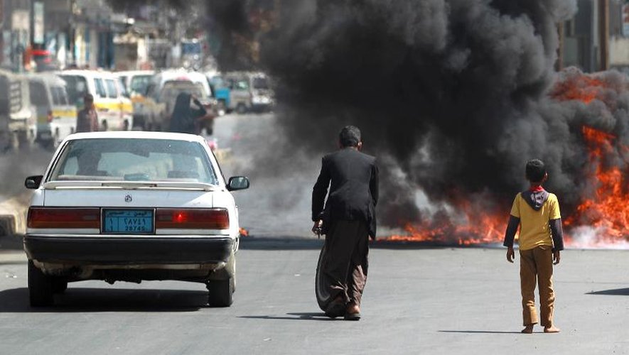 Des Yémenites mettent le feu à des pneus lors d'une manifestation à Sanaa, le 11 juin 2014