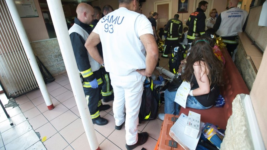 Des pompiers avec des habitants de l'immeuble où un incendie s'est déclar le 6 juin 2016 à Saint-Denis