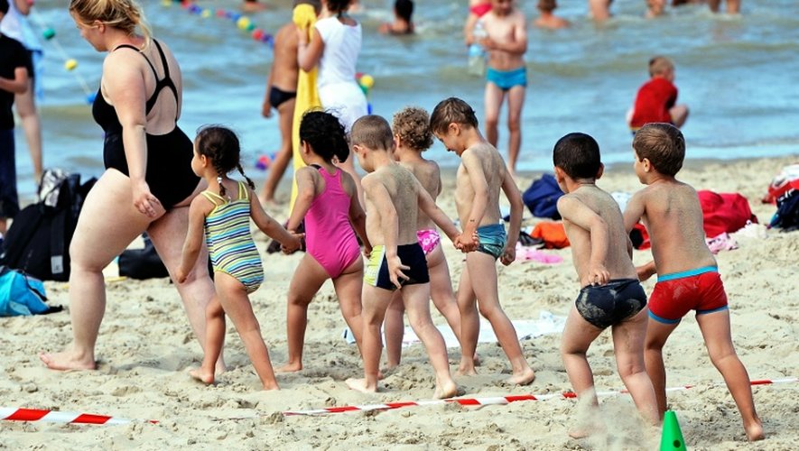 Des enfants d'un camp de vacances et leur monitrice sur la plage le 25 juillet 2013 à   Bray-Dunes dans le nord de la France