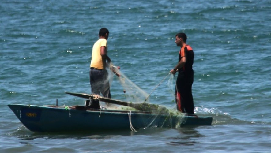 Des pêcheurs palestiniens près d'un bateau de la marine égyptienne touché par une attaque au large de la péninsule du Sinaï, le 16 juillet 2015