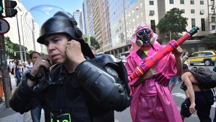 Un policier anti-émeute (g) et un manifestant anti-Mondial (d) à Rio de Janeiro, le 12 juin 2014