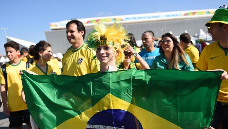 Des supporteurs posent devant l'Arena Corinthians à Sao Paulo où aura lieu le match d'ouverture du Mondial-2014 entre le Brésil et la Croatie