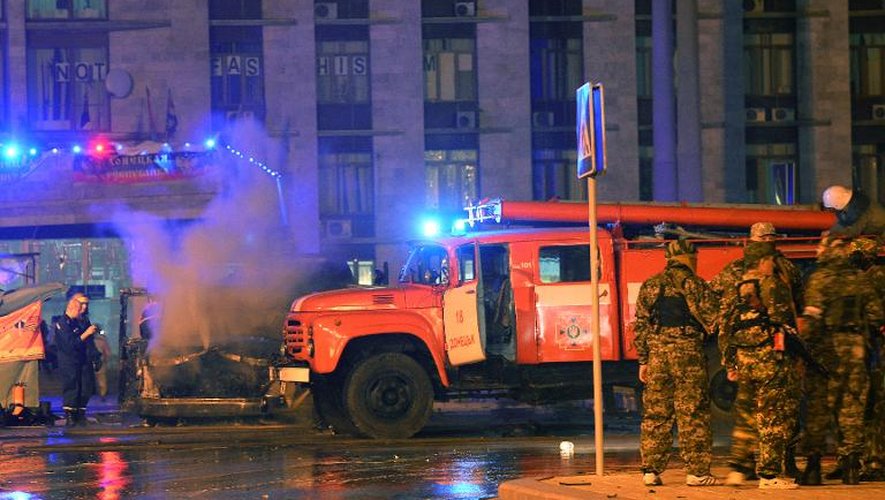 Des pompiers ukrainiens éteignent une incendie provoquée par l'explosion d'une voiture devant le siège de l'administration régionale, pris par les pro-russes à Donetsk, en Ukraine, le 12 juin 2014