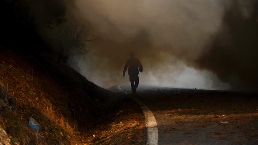 Un pompier marche sur une route de Caramulo au milieu de la fumée le 30 août 2013