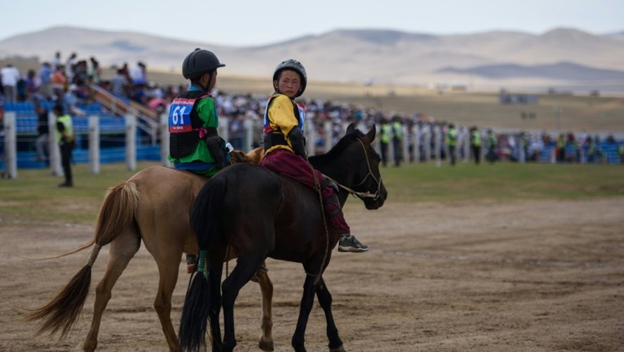 Purevsurengiin Togtokhsuren (d), un jeune jockey mongol de 13 ans, participe au festival d'été, le Naadam, le 11 juillet 2015 à Khui Doloon Khudag