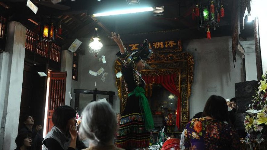 Une danseuse de Len Dong jette des billets durant une performance dans un temple d'Hanoï le 25 mars 2014