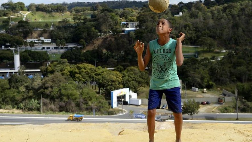 Un jeune brésilien joue au football près de Belo Horizonte le 11 juin 2014