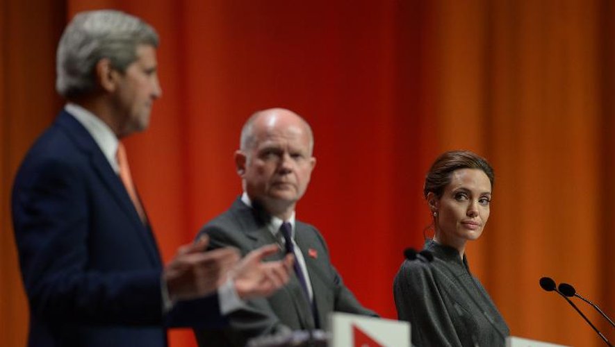 Le secrétaire d'Etat américain John Kerry, le ministre des Affaires étrangères britannique William Hague et l'actrice américaine Angelina Jolie lors du sommet sur les violences sexuelles en temps de conflit, le 13 juin 2014 à Londres