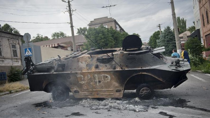 Un véhicule blindé brûlé détenu par des insurgés prorusses à Maioupol, dans l'est de l'Ukraine, le 13 juin 2014