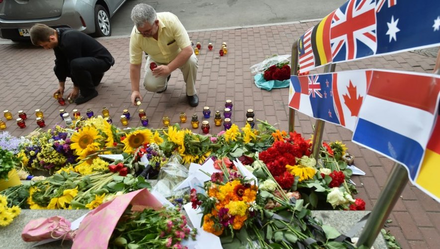 Des gens placent des bougies devant l'ambassade des Pays-Bas à Kiev le 17 juillet 2015 à la mémoire des victimes du crash du vol MH17 de la Malaysian Airlines en Ukraine