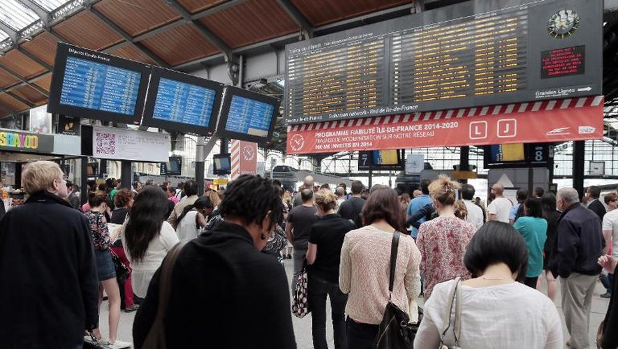 Des passagers regardent les tableaux d'affichage à la gare Saint-Lazare à Paris, le 13 juin 2014