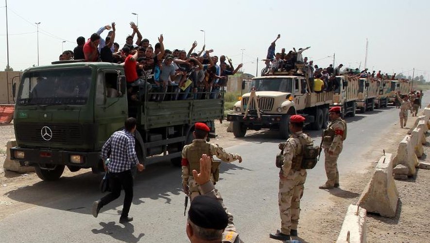 Volontaires juchés sur des camions recrutés par l'armée irakienne pour combattre les jihadistes, le 13 juin 2014 à Bagdad
