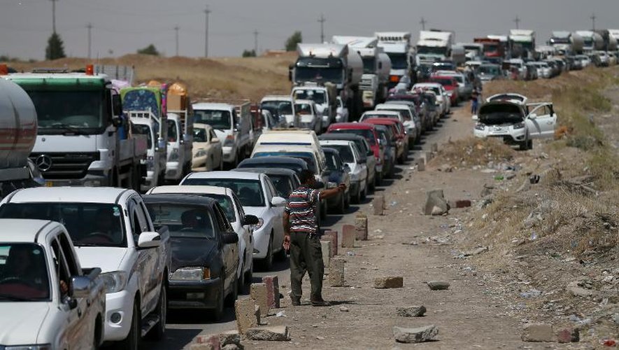 Des familles irakiennes arrivent à un checkpoint 80 km à l'ouest d'Arbil après avoir quitté leurs domiciles, le 14 juin 2014