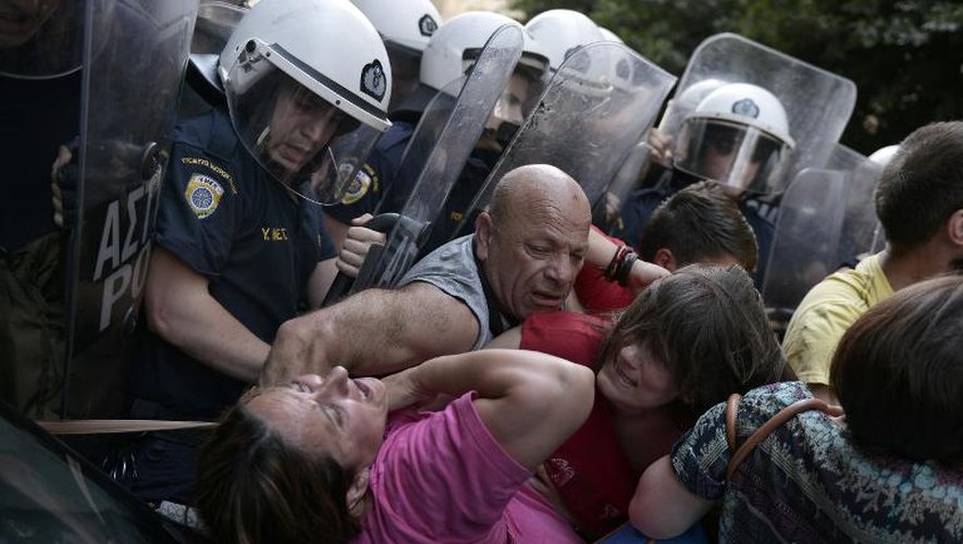 Des agents de nettoyage, et femmes de ménage licenciées du ministère des Finances grec s'opposent à la police, le 12 juin 2014