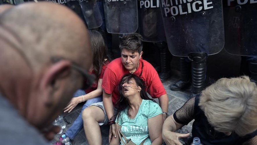 Une femme de ménage licenciée s'effondre après un affrontement avec la police devant le ministère à Athènes le 12 juin 2014