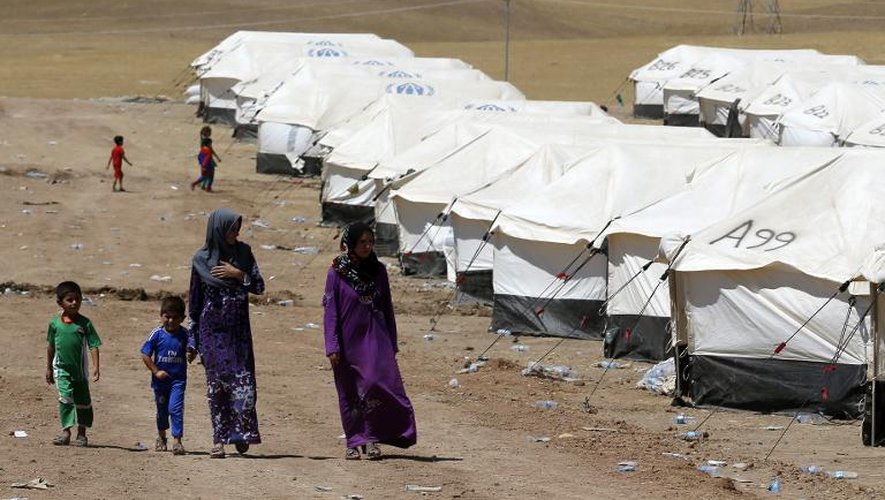 Des femmes, fuyant la violence des combats, s'installent avec leurs enfants dans un camp temporaire le 16 juin 2014 à Aski kalak, à 40 km à l'ouest d'Erbil au nord de l'Irak