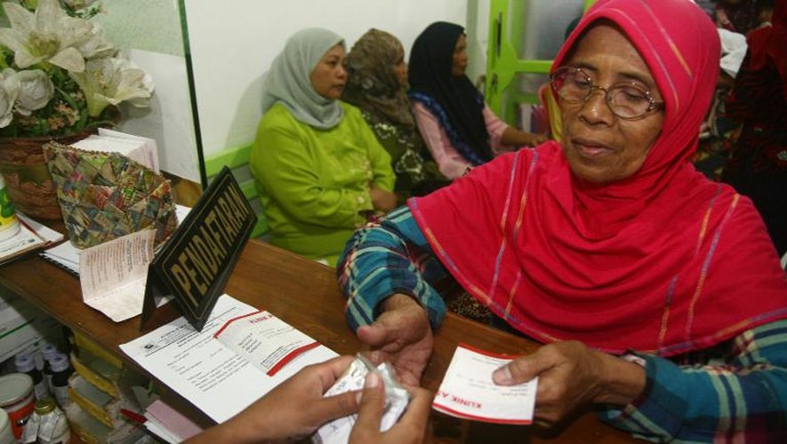 Une femme reçoit des médicaments le 26 avril 2014 à la clinique Bumi Ayu dans l'île de Java