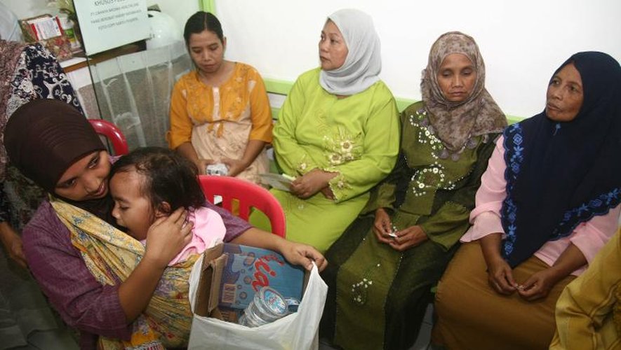 Une jeune maman apporte un sac de déchets à la clinique Bumi Ayu dans l'île de Java en échange de soins pour son enfant, le 26 avril 2014