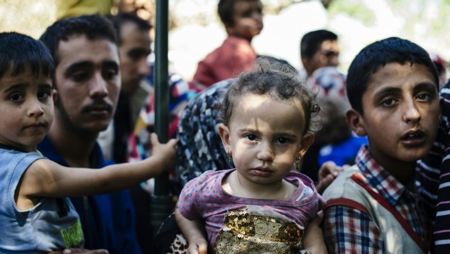 Des enfants et leurs parents  font la file pour obtenir le document qui légalise pour 72 heures leur séjour en Serbie, le 16 juillet 2015 à Presevo, près de la frontière macédoine