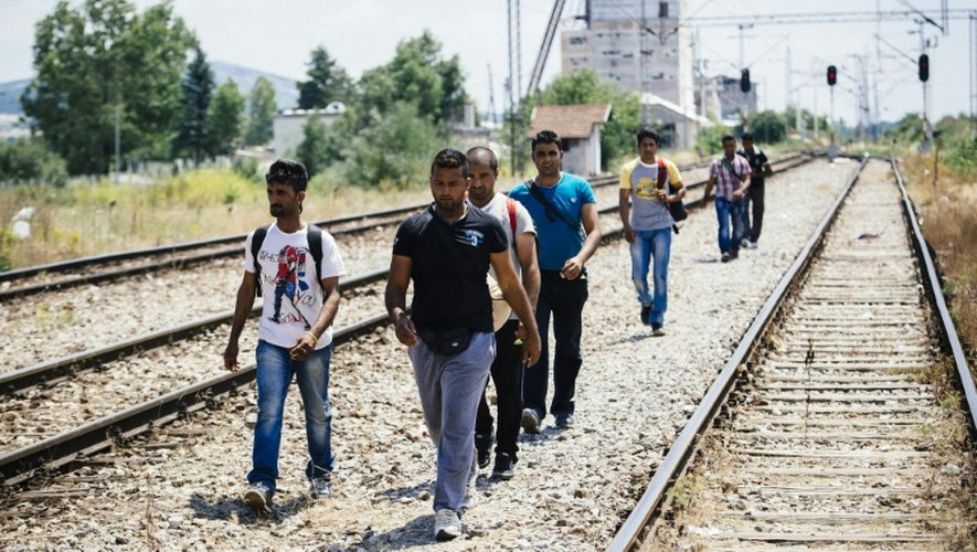 Des migrants longent la ligne de chemin de fer près de la ville de Presevo, en Serbie, à la frontière avec la Macédoine, le 16 juillet 2015