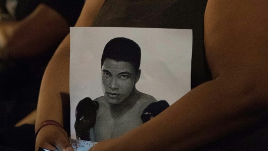 Une femme porte un portrait de Mohamed Ali, le 10 juin 2016 à Louisville, Etats-Unis