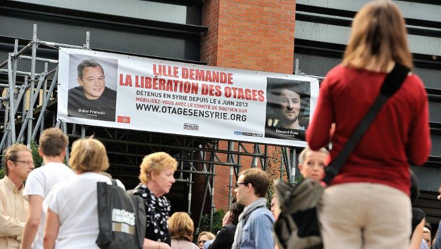 Des passants écoutent un discours du maire de Lille, après le dévoilement d'une banderole de soutien à Didier François et Edouard Elias sur l'hôtel de ville, le 6 septembre 2013