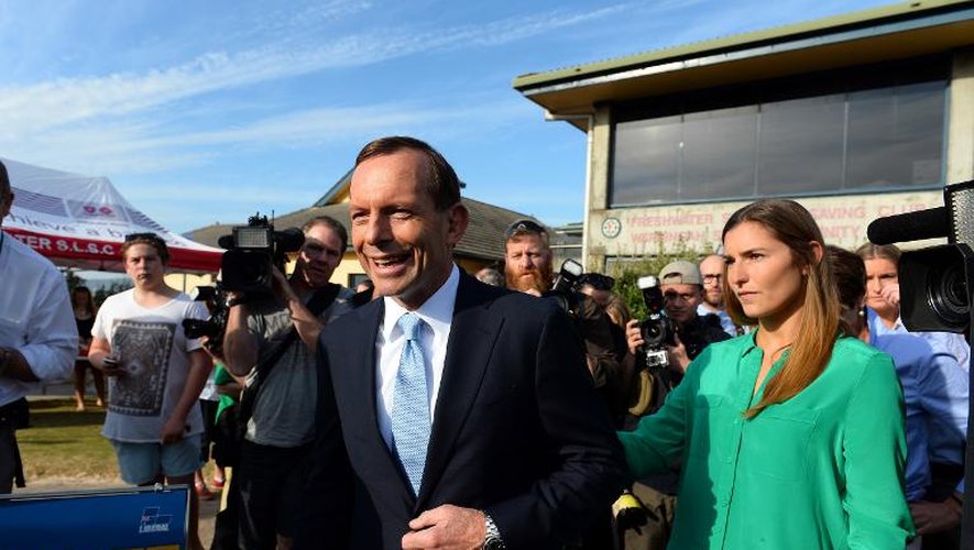 Le conservateur Tony Abbott (c) à l'extérieur d'un bureau de vote, le 7 septembre 2013 à Sydney