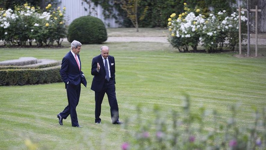 Laurent Fabius (d) et John Kerry (g) discutent dans les jardins du ministère des Affaires étrangères à Paris, le 7 septembre 2013