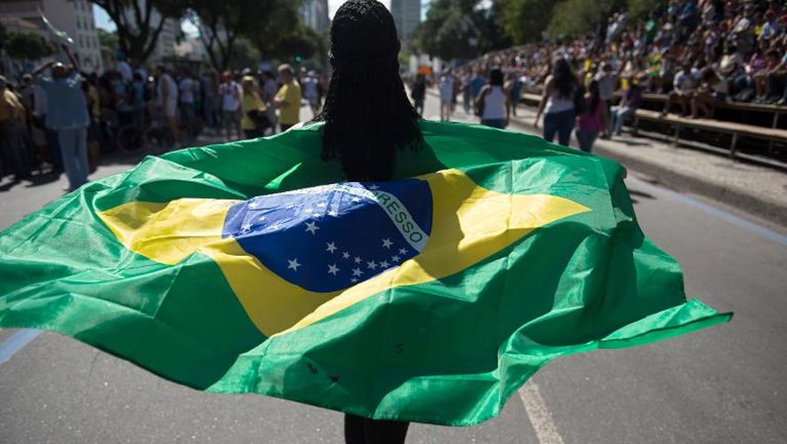 Une femme brandit un drapeau brésilien en marge d'un défilé militaire à Rio de Janeiro, le 7 septembre 2013