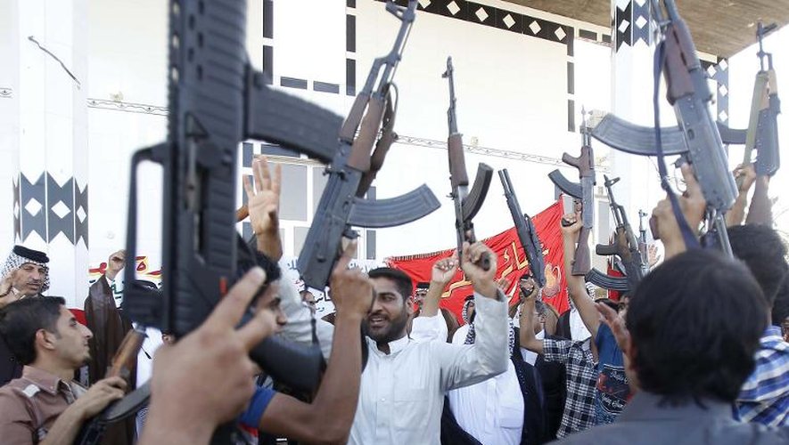 Des hommes appartenant à des tribus chiites brandissent des armes pour montrer leur détermination à rejoindre les forces de sécurité itakiennes pour lutter contre les jihadistes, à Karbala, le 17 juin 2014