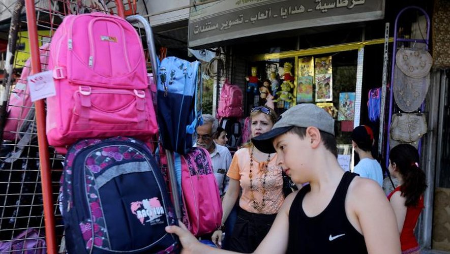 Un jeune syrien choisit un sac d'école dans une boutique de Damas, le 8 septembre 2013