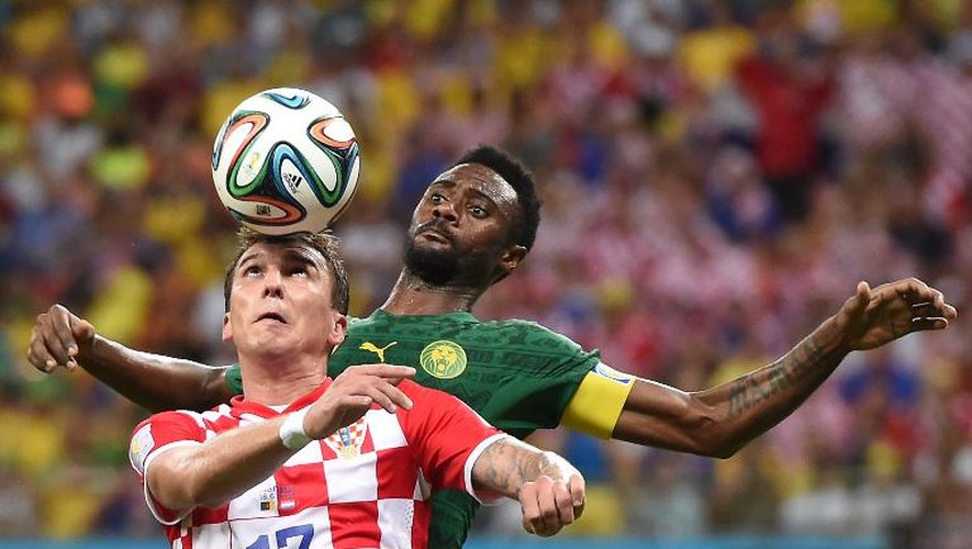 L'attaquant croate Mario Mandzukic (g) devance le défenseur camerounais Nicolas Nkoulou lors d'un match du Mondial à Manaus, le 18 juin 2014