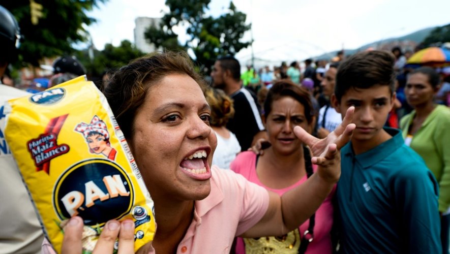 Une femme interpelle les forces de l'ordre dans la file d'attente d'un supermarché à Caracas, le 11 juin 2016