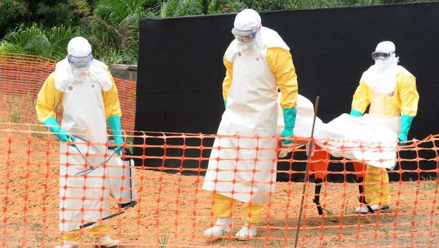 Des membres de Médecins sans frontière transportant le corps d'un défunt de la fièvre Ebola à Guékédou, en Guinée, le 1er avril 2014