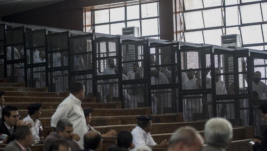 Des membres de la confrérie des Frères Musulmans, dans des cages, pendant leur procès au Caire le 7 juin 2014