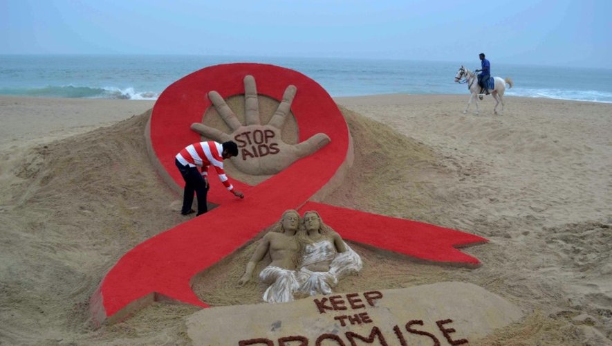 L'indien Sudersan Pattnaik donne les dernières touches le 29 novembre 2013,  veille de la Journée mondiale contre le sida, à una sculpture sur sable à Puri, 65 km à l'est de Bhubaneswara, appelant à accroître les efforts pour vaincre l'épidémie