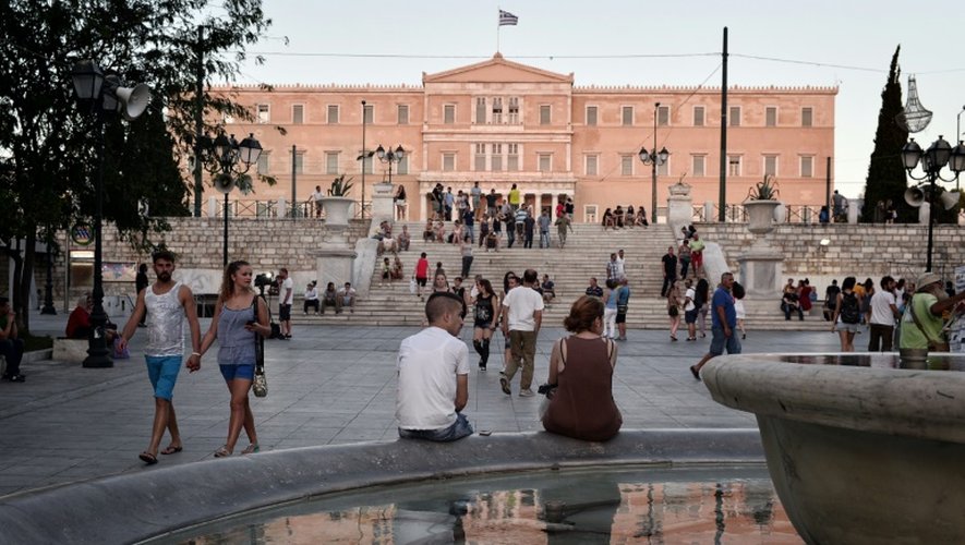 Des passants devant le Parlement grec, place Syntagma à Athènes, le 21 juillet