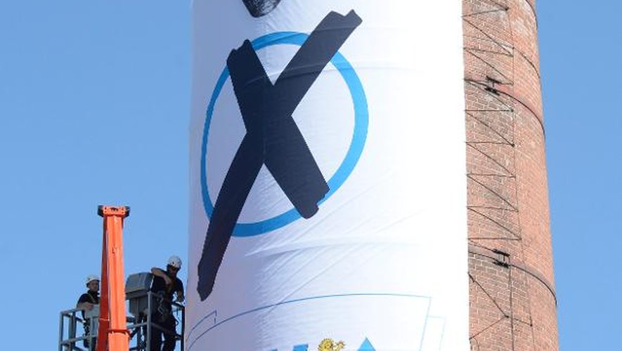 Des ouvriers tendent une affiche de l'Union chrétienne-sociale (CSU) sur une cheminée le 4 septembre 2013, à Munich