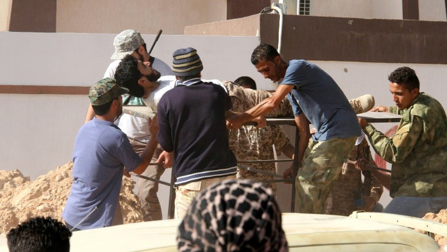 Un blessé parmi les forces pro gouvernementales libyennes est transporté sur un brancard, à Syrte le 12 juin 2016 lors de combats contre les jihadistes de l'EI