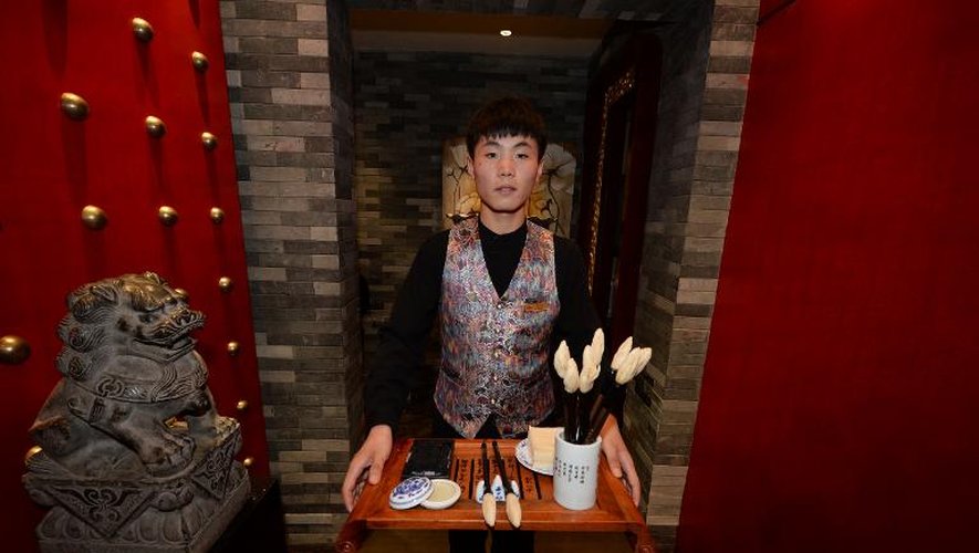 Un homme présente un kit de calligraphie comestible dans un restaurant de Jinan, dans la province du Shandong, le 24 juillet 2013