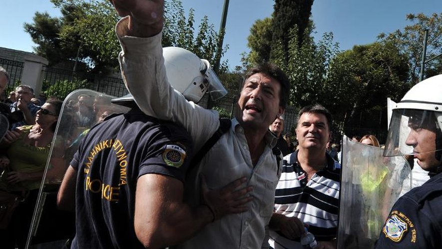 Des policiers retiennent un manifestant devant le ministère de la Réforme administrative, le 16 septembre 2013 à Athènes