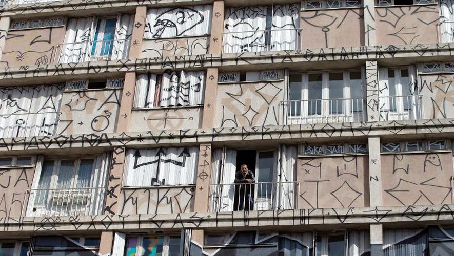 Le galériste Mehdi ben Cheikh pose à une fenêtre du bâtiment La Tour, voué à la démolition, où des artistes de street art donnent libre cours à leur inspiration, le 10 septembre 2013 à Paris