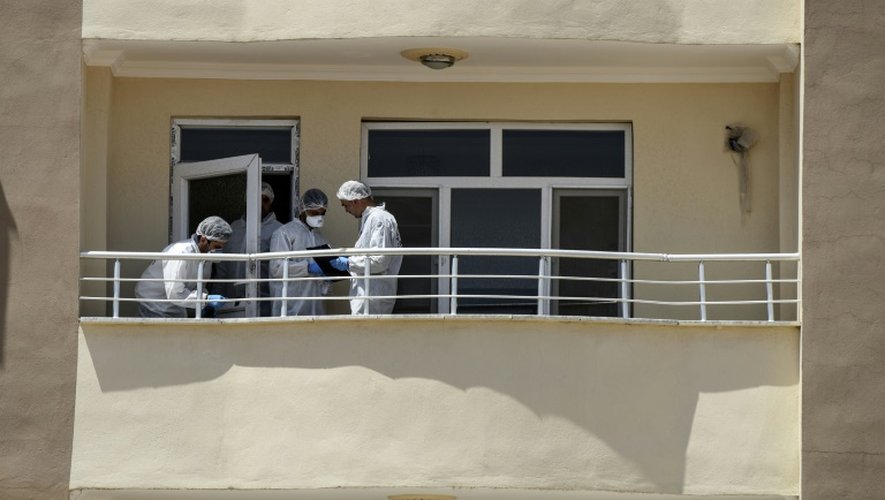 Des enquêteurs de la police scientifique travaillent sur le balcon d'un appartement où deux policers turcs ont été tués par balles à Ceylanpinar, à la frontière avec la Syrie, le 22 juillet 2015