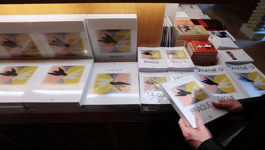 Des visiteurs découvrent le catalogue de la rétrospective des oeuvres du peintre français Georges Braque, au Grand Palais, à Paris, le 16 septembre 2013