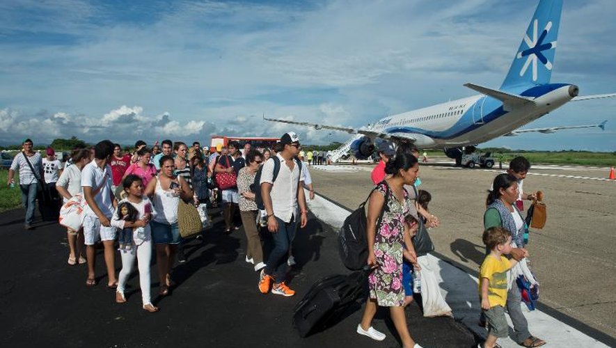 Des touristes attendent un avion à l'aéroport d'Acapulco, le 17 septembre 2013 au Mexique