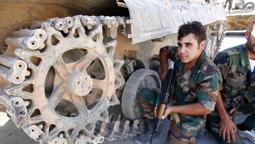 Des soldats syriens adossés à un tank, le 18 septembre 2013 à Maaloula