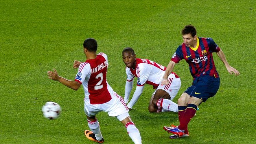Lionel Messi (d), du FC Barcelone, marque entre deux défenseurs de l'Ajax Amstedrdam en Ligue des champions le 18 septembre 2013 au Camp Nou