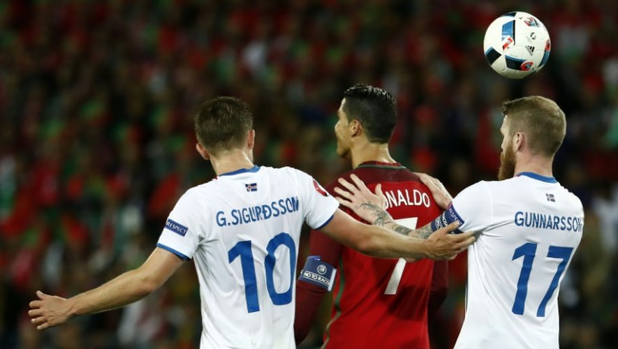 L'attaquant portugais Cristiano Ronaldo, marqué de près par les Islandais Gylfi Sigurdsson et Aron Gunnarsson lors de l'Euro, le 14 juin 2016 à Saint-Etienne