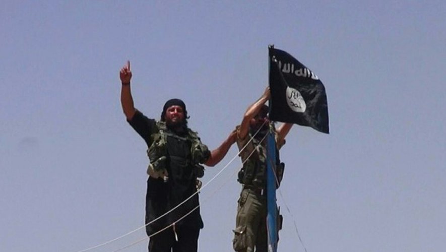 Image diffusée le 11 juin 2014 par le compte Twitter jihadiste Al-Baraka montrant des membres de l'organisation Etat islamique (EI) agitant un drapeau dans la frontière entre la province irakienne de Ninive et la ville syrienne de Al-Hasakah